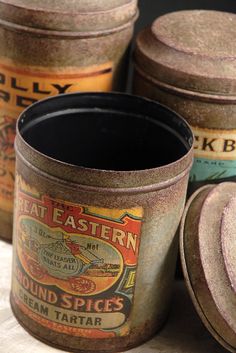 four old fashioned tins sitting on top of a table