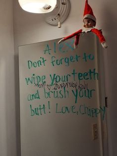 an elf is hanging on the wall next to a sign