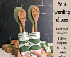 two wooden spatulas with green and white stripes on them are held up by someone's hand