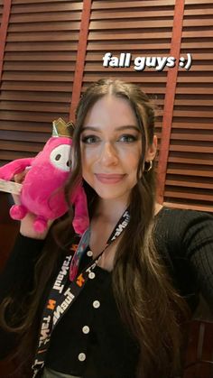 a woman is holding a pink stuffed animal