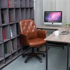 a brown leather office chair sitting in front of a desk with a computer on it