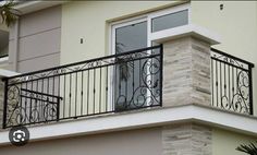 a balcony with wrought iron balconies and an open window on the second floor