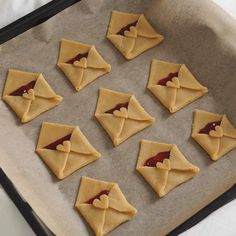 nine cookies with peanut butter and jelly in the shape of envelopes on a baking sheet