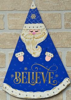 a blue and white sign that says believe with a santa clause on it's face