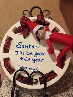 a plate with an elf on it that says, santa i'll be good this year wink wink