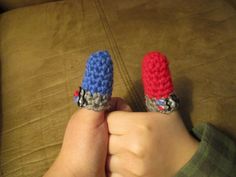 two small crocheted objects are held in the palm of a child's hand