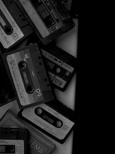 a pile of old cassettes sitting on top of each other in black and white