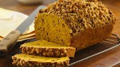 a loaf of bread sitting on top of a wooden cutting board next to a knife