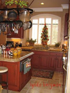 a kitchen filled with lots of pots and pans hanging from the ceiling next to an oven