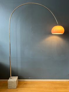 a lamp that is sitting on top of a wooden floor next to a blue wall