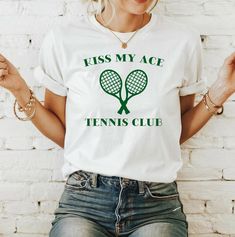 If you're a keen tennis player and keep serving those aces, this Kiss My Ace Green Tennis Shirt is perfect for you! Designed in a classic fit, this unisex t-shirt is easy to wear with jeans or tucked into a tennis skirt or shorts. Made from a medium weight US grown cotton, this printed white tee is super soft and durable. When everyday is tennis season, this tennis gift is a must for tennis player friends. Key Points *Gildan 5000 t-shirt style *100% US Cotton *Medium Weight Cotton (5.3 oz/yd²) * Cotton Tennis Tops With Letter Print, White Graphic Tee For Tennis, Graphic Tee With Letter Print For Tennis, Green Short Sleeve Tennis Top, Green Graphic Print Tennis Tops, Tennis Shirts Designs Ideas, Sporty Letter Print T-shirt For Tennis, Cotton Letter Print T-shirt For Tennis, Green Casual Tennis T-shirt