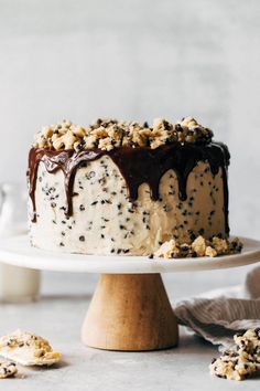 a cake sitting on top of a white plate covered in frosting and toppings