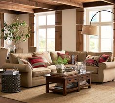 a living room filled with lots of furniture next to two windows and a coffee table