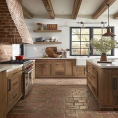 a kitchen with brick flooring and wooden cabinets in the center, along with open windows