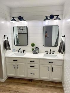 a white bathroom with two sinks and mirrors