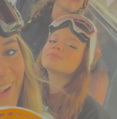 three girls wearing goggles and eating donuts