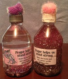 two bottles filled with liquid sitting on top of a wooden table next to each other