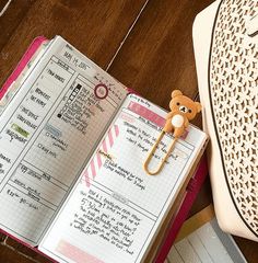 an open planner book sitting on top of a wooden table