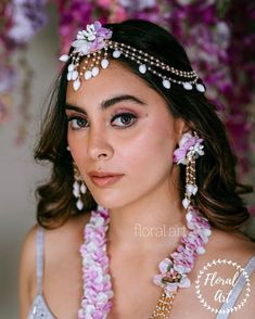 a woman with flowers in her hair and jewelry