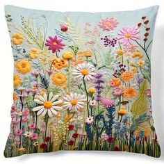 a pillow with flowers painted on the front and back of it's sides, in various colors