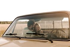 a man and woman sitting in the driver's seat of a truck