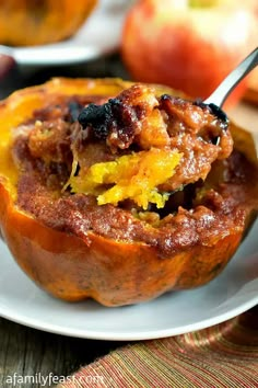 a close up of a muffin on a plate with an apple in the background