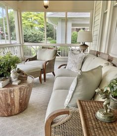 a living room with couches and chairs on the front porch, covered in wicker