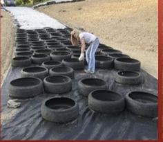 a woman bending over to pick up some tires