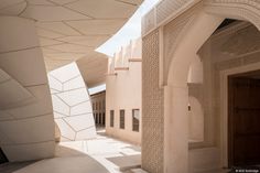 an archway between two buildings with white walls