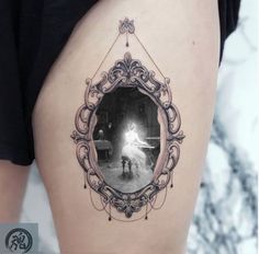 a woman with a mirror tattoo on her thigh