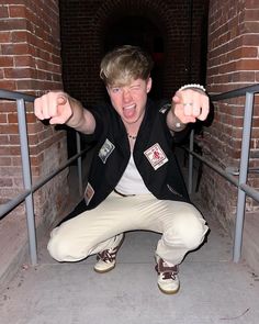 a man sitting on the ground with his hands in the air