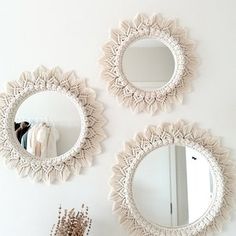 three round mirrors hanging on the wall above a dresser and mirror in a white room