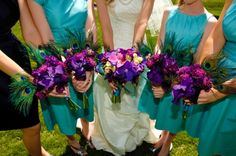 a group of women standing next to each other holding purple and green flowers in their hands