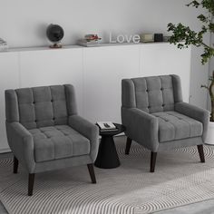 two gray chairs sitting next to each other on top of a carpeted floor in front of a white wall