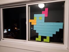 a window with sticky notes taped to the side and an image of a bird on it