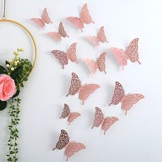 a bunch of pink butterflies sitting on top of a white wall next to a flower