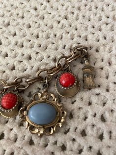 Red and blue charm bracelet. Doesn't have a closure! Can be used as decor or can repair the closure Retro Red Bracelet Jewelry, Red Metal Costume Jewelry Bracelets, Red Metal Costume Jewelry Bracelet, Vintage Red Jewelry With Jubilee Bracelet, Vintage Red Jubilee Bracelet, Red Vintage Jewelry With Jubilee Bracelet, Vintage Charm Costume Jewelry Bracelet, Vintage Charm Bracelet With Lobster Clasp, Vintage Dangle Charms Bracelets