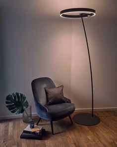 a lamp that is on top of a table next to a chair and a book