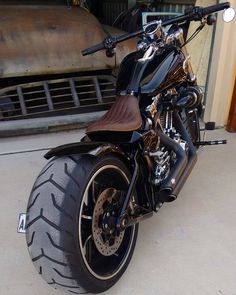 a black motorcycle parked in front of a building with no one on it's bike