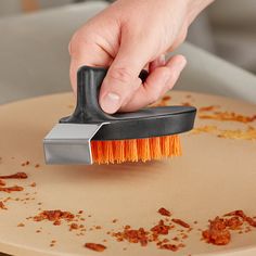 a close up of a person cleaning a table with a brush