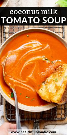 a bowl of tomato soup with bread on the side and text overlay that reads coconut milk tomato soup