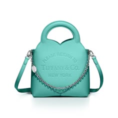 Inspired by one of the House’s most distinctive designs, the heart-shaped Return to Tiffany® handbags are crafted in supple leather and embellished with charm and chain link accents that nod to our iconic jewelry. Add a playful touch to every day with this mini tote. It’s embossed with our signature heart motif and designed with a detachable leather strap. An interior zip pocket keeps essentials organized. Tiffany Blue® Taurillon leather; 7.8 x 11 x 3.9"; Palladium-plated hardware, charms and ch Return To Tiffany, Fancy Things, Heart Motif, Mini Tote Bag, Mini Tote, Tiffany Blue, Nappa Leather, Blue Leather, Tiffany & Co.