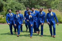 a group of men in blue suits walking across a field