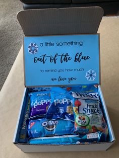 a blue box filled with snacks sitting on top of a table