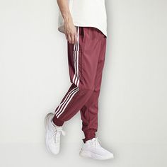 Whether you're exercising at home or at the gym, this adidas men's mid-rise workout pant is a wardrobe essential. It's made from a woven recycled fabric and features an adjustable drawstring waist, regular-fit, multiple pockets, and cuffed leg detail. Front Style: Flat FrontFeatures: Adjustable WaistClosure Type: Drawstring, Full ElasticFit: Regular FitPockets: 1 Cargo Side Pocket, 2 Side Slip PocketsRise: Mid RiseFiber Content: 100% Recycled PolyesterFabric Description: WovenInseam: 31 InLeg St Adidas Moisture-wicking Joggers For Streetwear, Adidas Sportswear Sweatpants For Gym, Sportswear Joggers With Three Stripes For Gym, Three Stripes Sportswear Joggers For Gym, Adidas Athleisure Sweatpants For Gym, Casual Red Activewear For Jogging, Red Casual Activewear For Jogging, Adidas Gym Pants With Three Stripes, Adidas Workout Joggers With Three Stripes