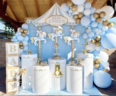 a blue and gold baby shower party with balloons, decorations, and decorating items