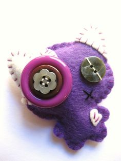 a purple and white stuffed animal with buttons on it