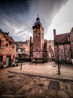 an old brick building with a clock tower in the middle of it's courtyard