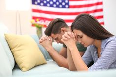 a man and woman sitting on a couch looking at each other with their hands together