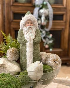 a glass bowl filled with ornaments and a santa clause figurine